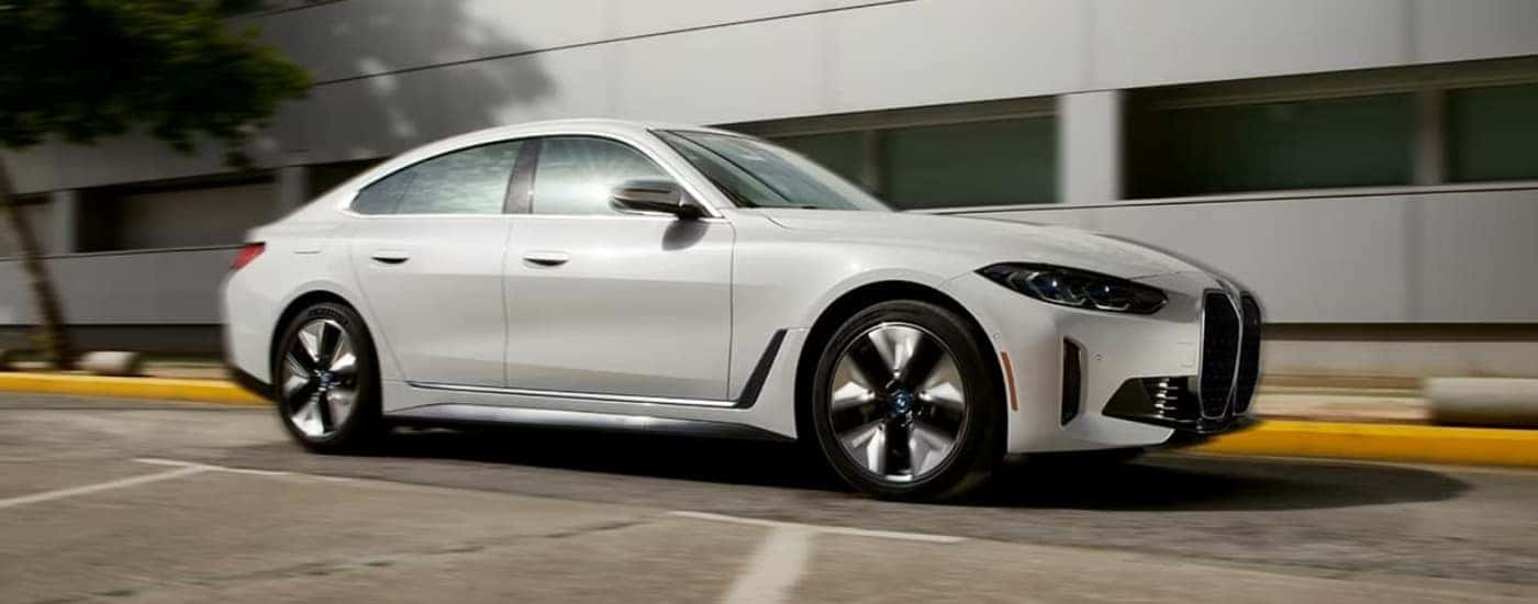 White 2024 BMW i4 Gran Coupe driving in a city