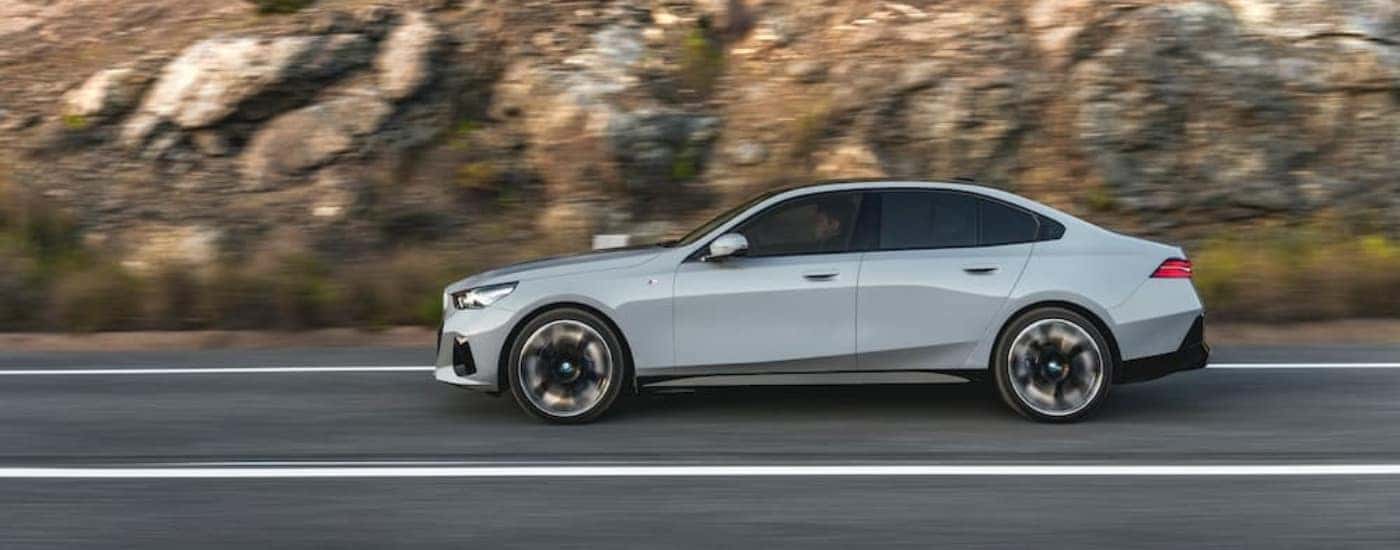 Grey 2024 BMW i5 driving on an open road