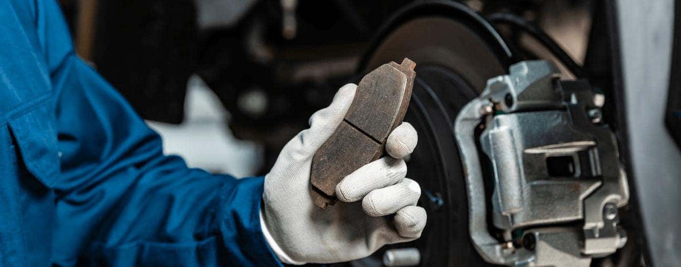 Mechanic holding a worn brake pad