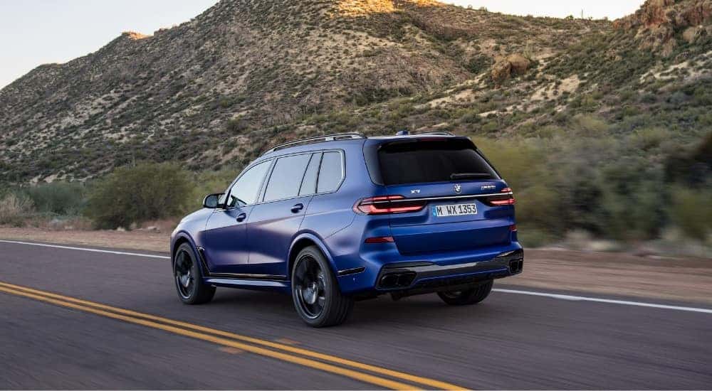 A blue 2025 BMW X7 for sale from the rear at an angle.
