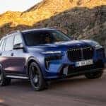A blue 2025 BMW X7 from the front at an angle.