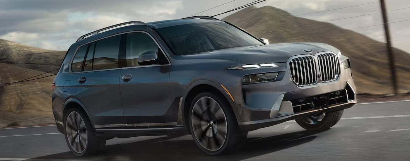 A gray 2026 BMW X7 driving down a highway