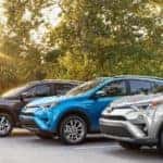RAV4s left to right - Gray XLE Hybrid, Blue Limited Hybrid, and Silver SE