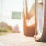 A closeup shows a flat tire on a car on the side of a road in Romeoville, IL.