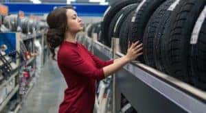 A woman is looking at tires on a rack at a Romeoville tire shop.