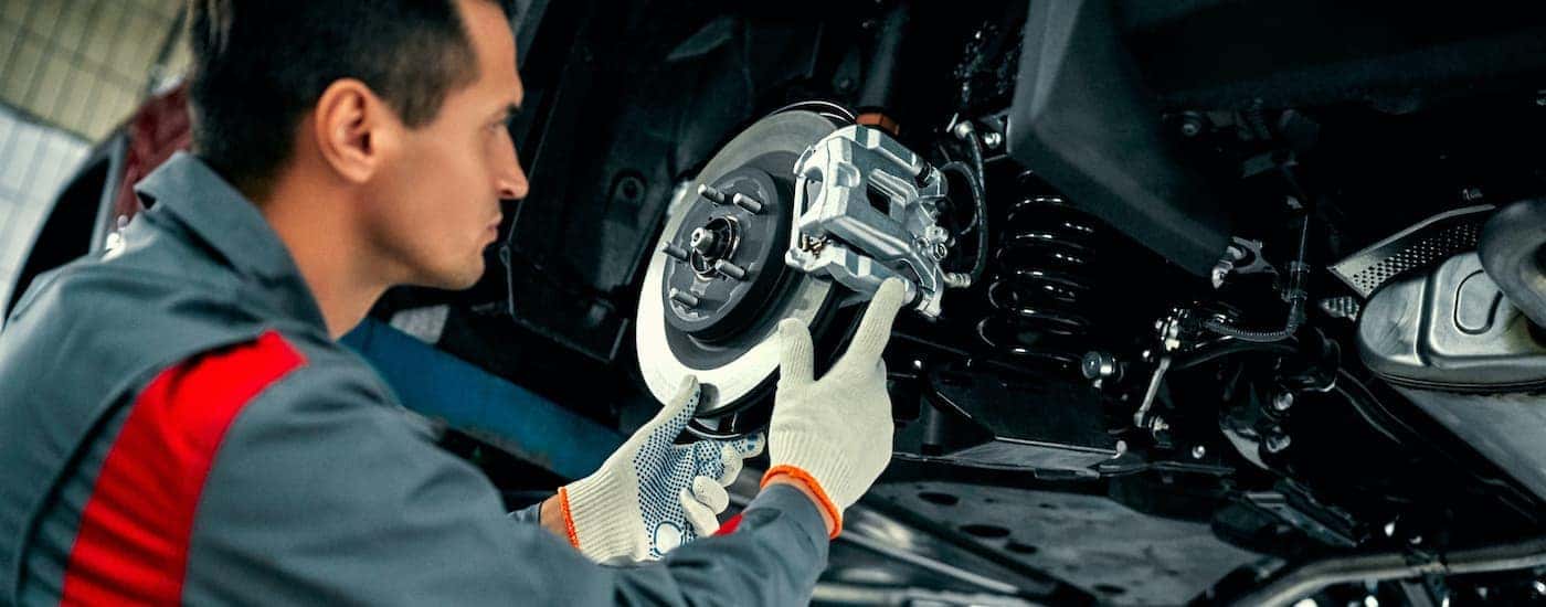 A mechanic is shown inspecting a caliper during a brake service.