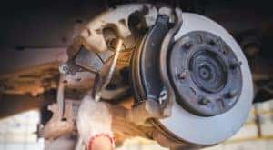 A close up is showing a brake pad being compressed on a caliper during a brake service.