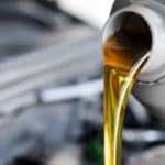 Oil is being poured over an engine bay.
