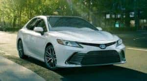 A white 2021 Toyota Camry is on a city street.