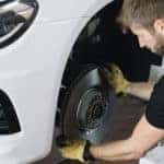A mechanic is replacing a brake pad at a Toyota service center.