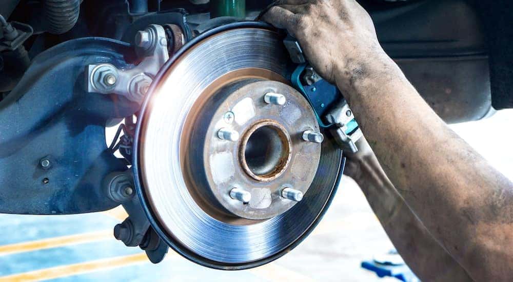 A mechanic is examining a brake pad during a Toyota brake service.