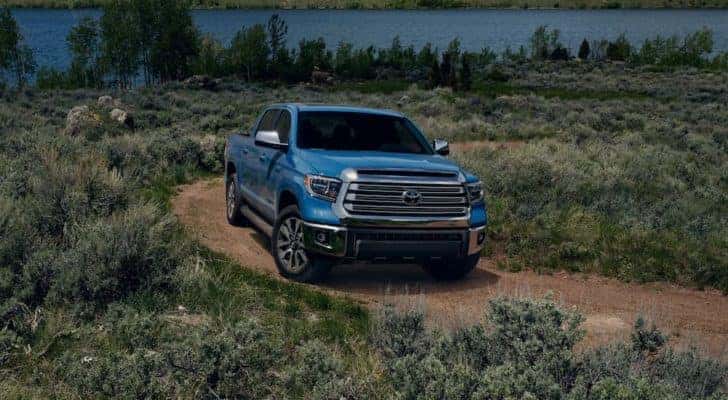 A blue 2021 Toyota Tundra is driving down a dirt path after leaving a Toyota Tundra Dealership.