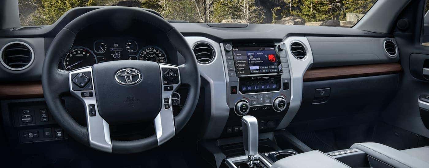 The interior of a 2021 Toyota Tundra shows the steering wheel and infotainment screen.