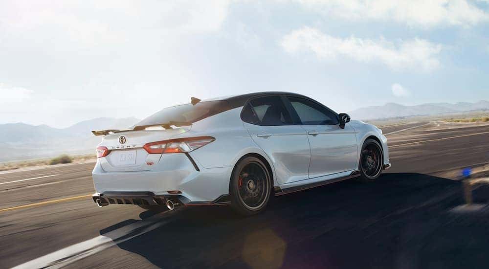 A white 2020 Toyota Camry TRD is shown rounding a corner after leaving a Illinois pre-owned Toyota dealer.
