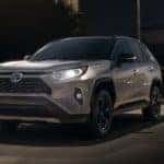 A silver 2020 Toyota RAV4 is shown from the front driving at night.