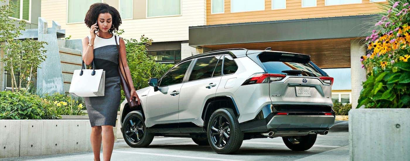 A woman is shown walking away from a silver 2021 Toyota RAV4.