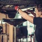 A mechanic is performing an oil change near you.