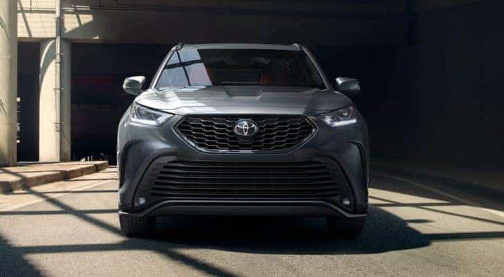 A grey 2021 Highlander XSE AWD is sown from the front parked in a concrete building.