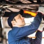 A mechanic is shown working underneath a vehicle during an oil change in Romeoville.