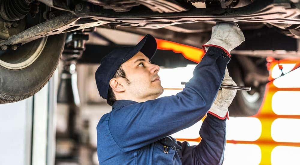 A mechanic is shown working underneath a vehicle during an oil change in Romeoville.