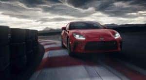 A red 2022 GR 86 is shown from the front driving on a track.