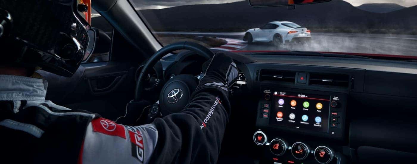 The black interior of a 2022 GR 86 shows the steering wheel and infotainment screen.