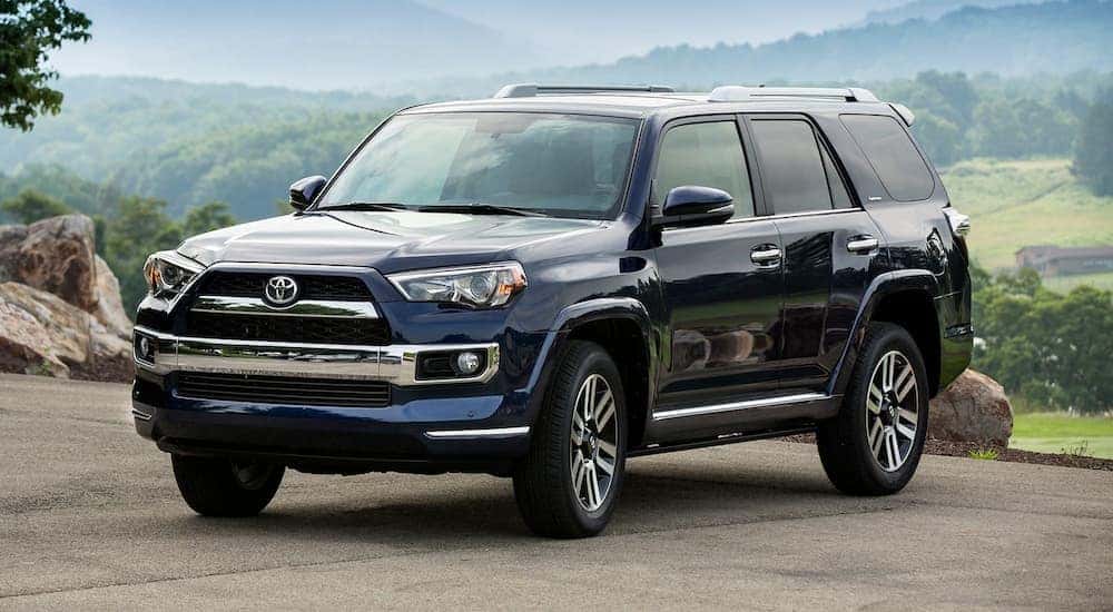 A blue 2018 Toyota 4Runner is shown parked near a certified pre-owned Toyota dealer.