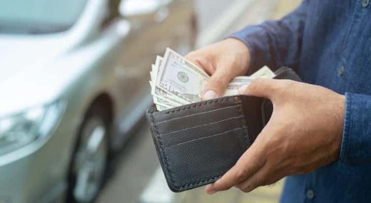cash in a wallet at a car dealership