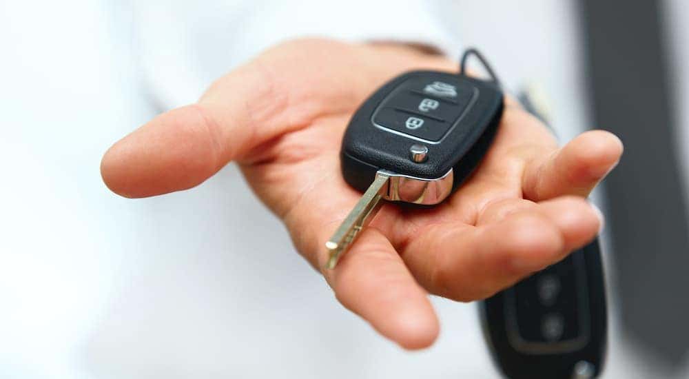 A hand is holding a car key.