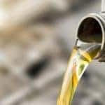 A bottle of oil is shown being poured into a engine.