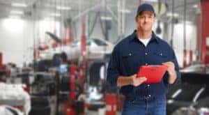 A mechanic is shown holding a clipboard at a collision repair shop in Romeoville.