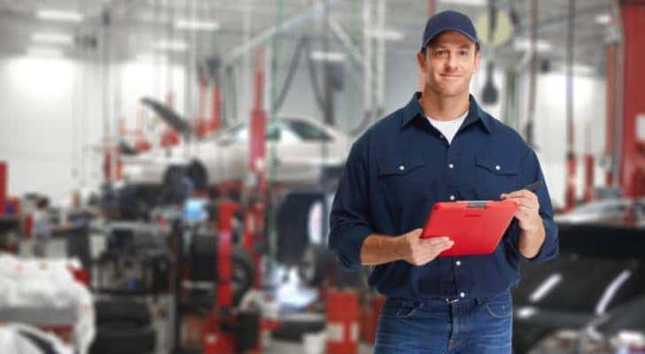 A mechanic is shown holding a clipboard at a collision repair shop in Romeoville.