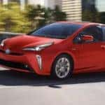 A red 2022 Toyota Prius Limited is shown from the side driving on an open road after leaving a Toyota Prius dealership.