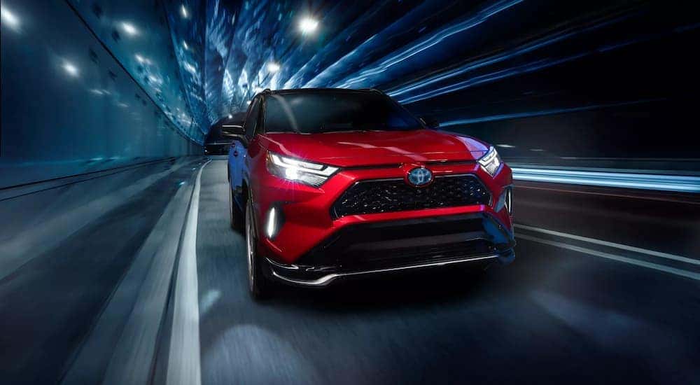 A red 2022 Toyota RAV4 Prime XSE is shown driving in a tunnel after leaving an EV dealership near you.