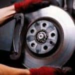A mechanic is shown performing a brake service.