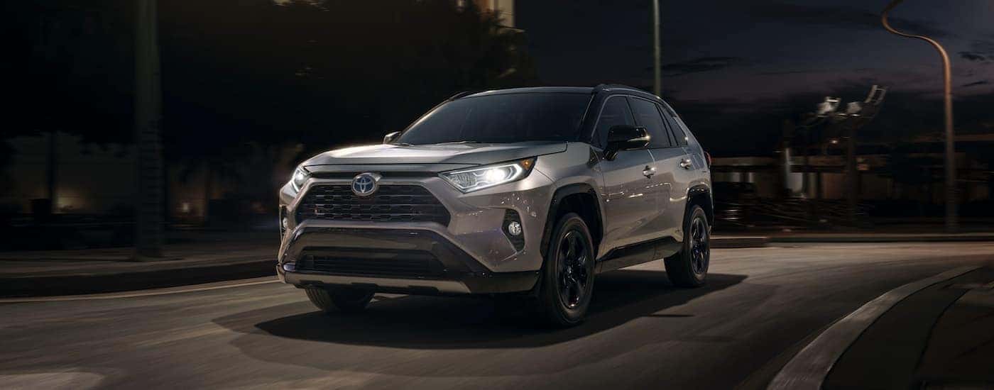A grey 2020 Toyota RAV4 is shown from the front driving on an open road after leaving a SUV Dealer near you.