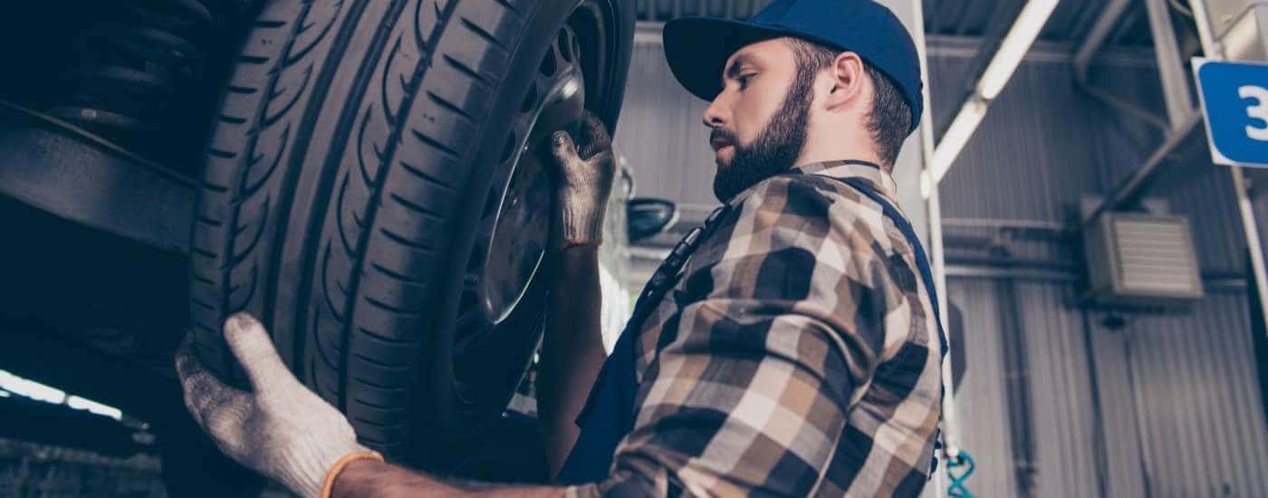 A tech is shown during a tire rotation.