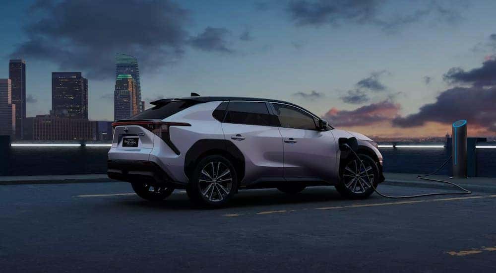 A silver Toyota bZ4X BEV is shown overlooking a city.
