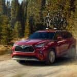 A red 2022 Toyota Highlander is shown from the front on a dirt trail.