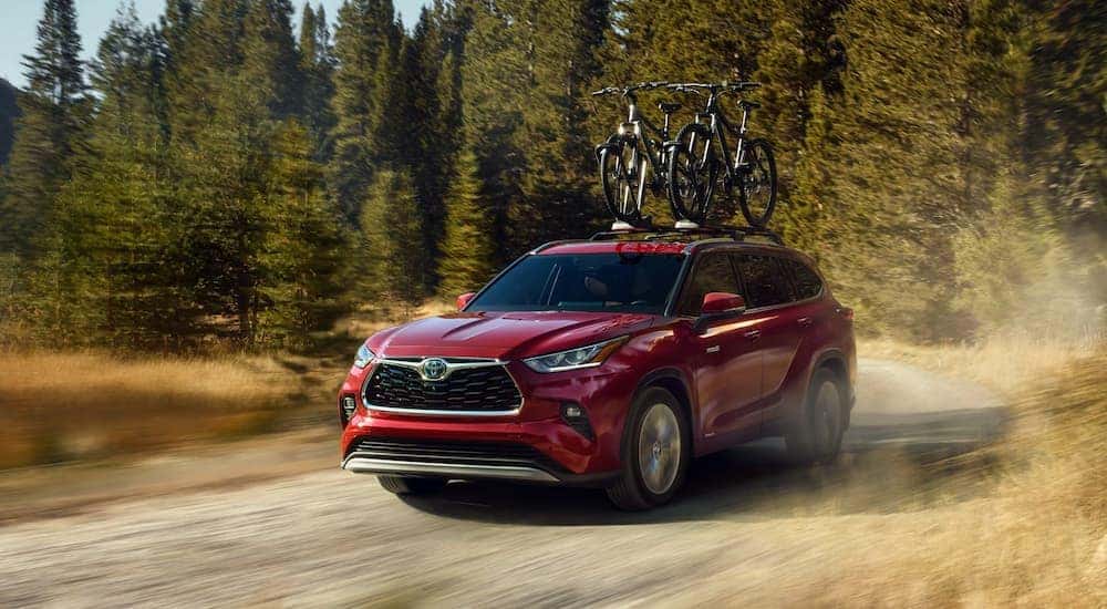 A red 2022 Toyota Highlander is shown from the front on a dirt trail.