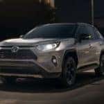 A silver 2020 Toyota RAV4 is shown driving at night.