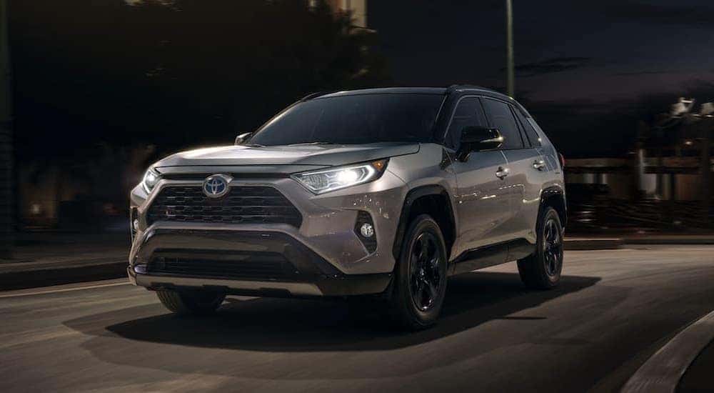 A silver 2020 Toyota RAV4 is shown driving at night.