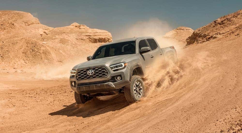 A tan 2020 Toyota Tacoma TRD is shown off-roading in a desert.