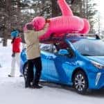 A blue 2022 Toyota Prius is shown parked in a snowy lot after looking at winter tires for sale.