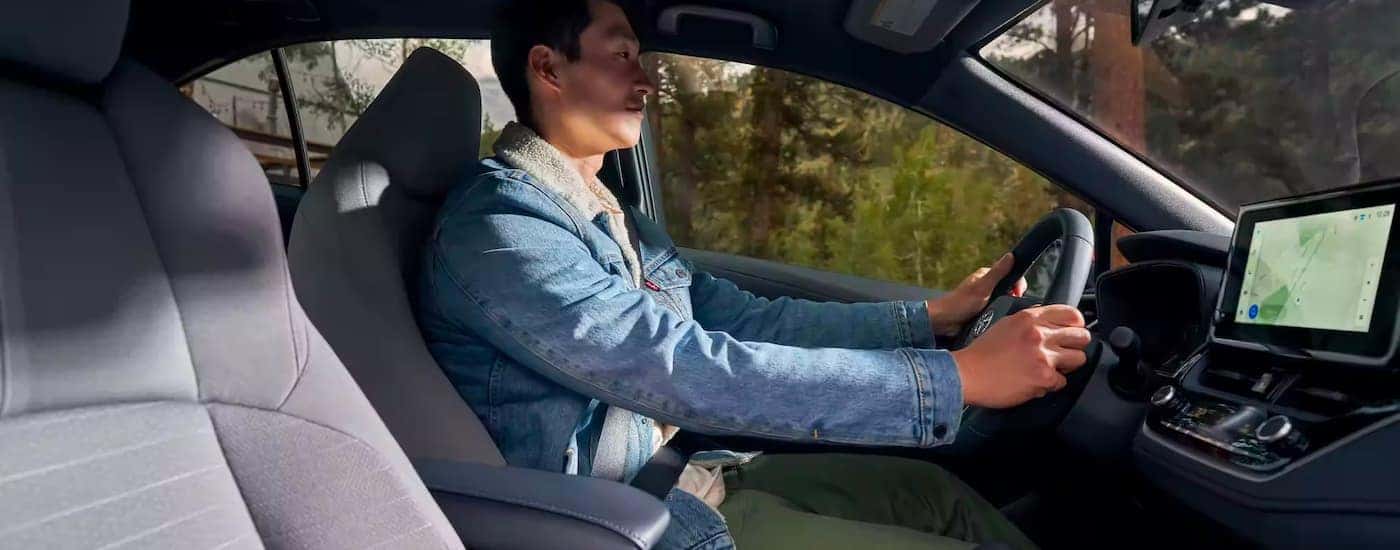 A person is shown driving a 2023 Toyota Corolla Hybrid SE after leaving a Toyota collision center.