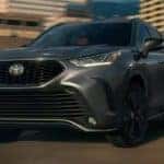 A grey 2023 Toyota Highlander XSE is shown from the front driving on an open road.