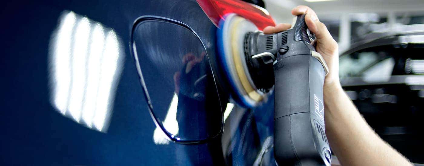 A blue car is shown being buffed.