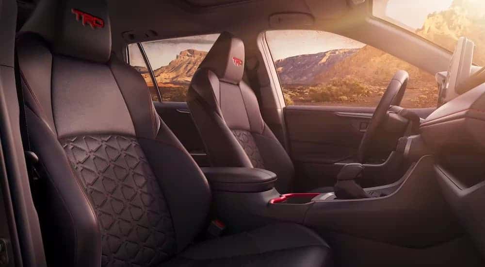 The black interior of a 2023 Toyota RAV4 TRD is shown from the passenger side.