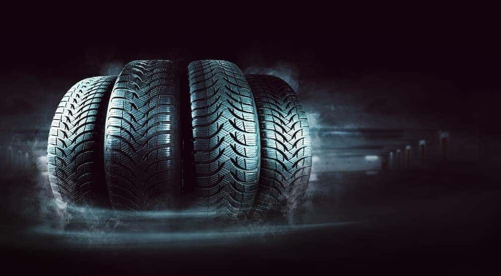 Four tires are shown in a dark garage.