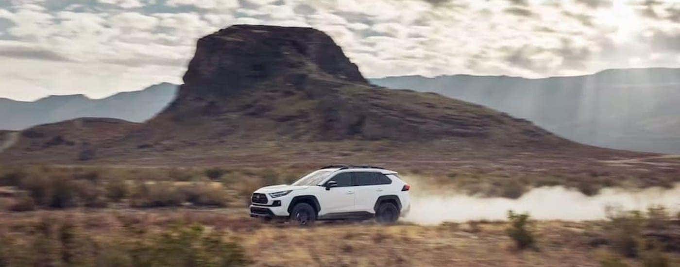 A white 2022 Toyota RAV4 is shown from the side after leaving a dealer that has a Toyota RAV4 for sale.